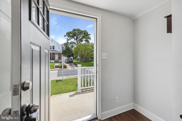 doorway to outside featuring dark wood-type flooring and baseboards