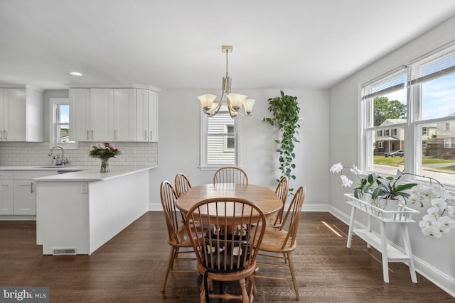 dining space featuring healthy amount of natural light, a chandelier, dark wood-style floors, and recessed lighting