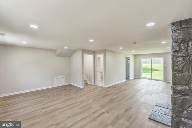 unfurnished living room with baseboards, recessed lighting, and light wood-type flooring