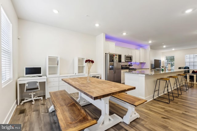 kitchen with stainless steel appliances, a kitchen island with sink, visible vents, butcher block countertops, and white cabinetry