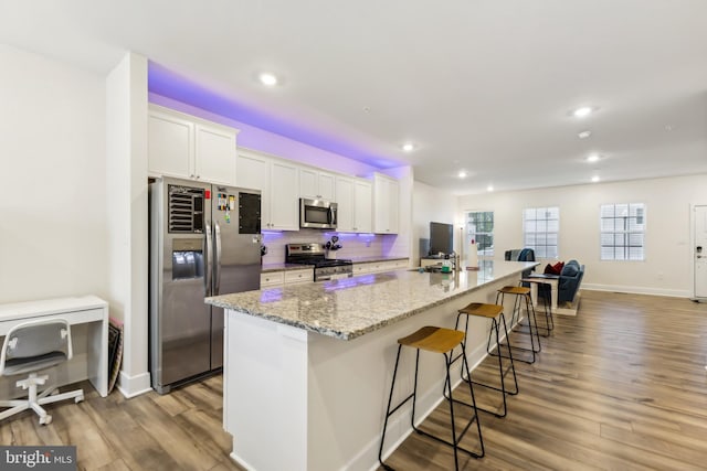 kitchen featuring recessed lighting, appliances with stainless steel finishes, white cabinetry, and a large island