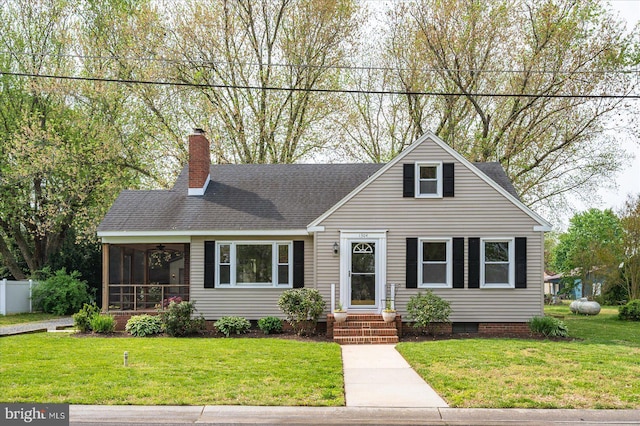 view of front of home with roof with shingles, ceiling fan, a chimney, and a front yard