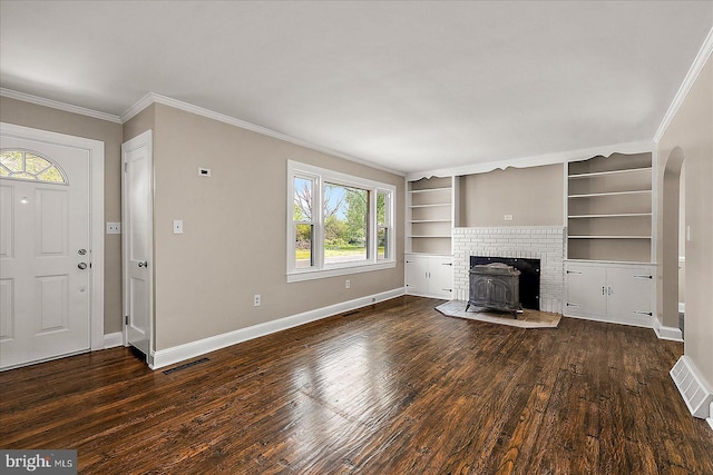 unfurnished living room featuring a wood stove, baseboards, and dark wood-style floors