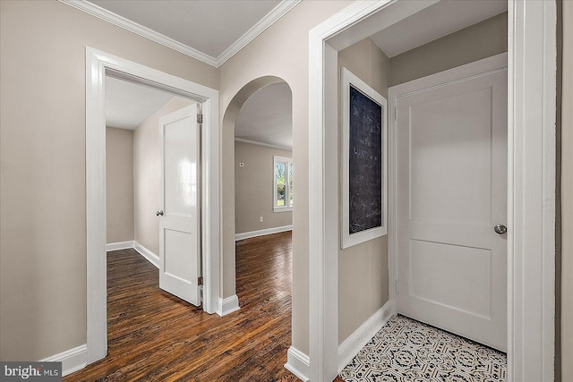 hall with arched walkways, baseboards, crown molding, and wood finished floors