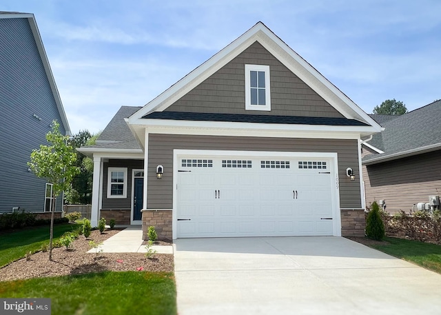craftsman-style home featuring driveway and stone siding