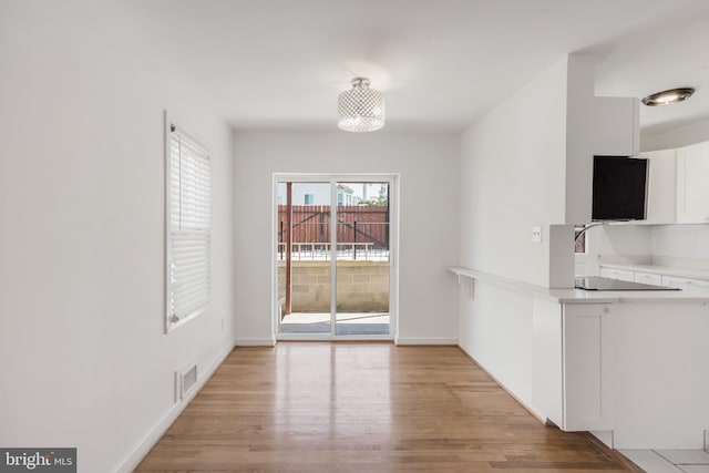647 Emerson St NE, Washington, DC 20017 - unfurnished dining area with light wood-type flooring, visible vents, and baseboards