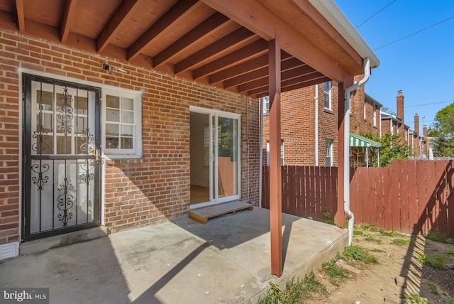 647 Emerson St NE, Washington, DC 20017 - doorway to property with fence, a patio area, and brick siding