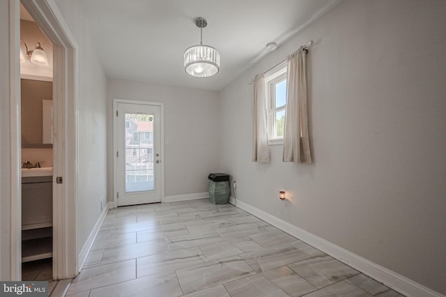 interior space featuring baseboards, a sink, and a wealth of natural light