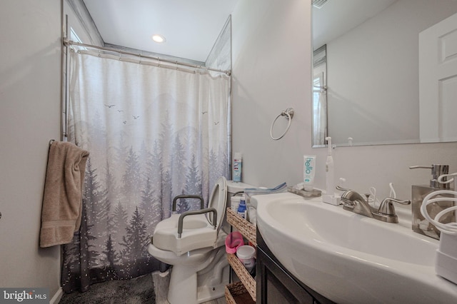 bathroom with a shower with shower curtain, toilet, and a sink
