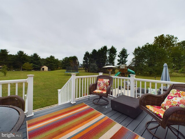 10037 Grapevine Rd, Mardela Springs, MD 21837 - wooden terrace with a trampoline, a playground, a yard, a storage shed, and an outbuilding