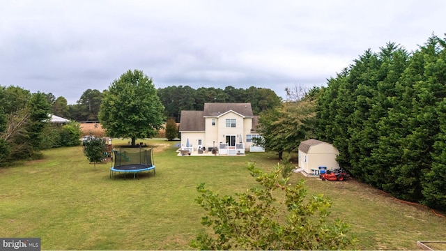 10037 Grapevine Rd, Mardela Springs, MD 21837 - view of green lawn with a trampoline, a storage unit, an outdoor structure, and a patio area