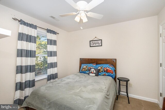 carpeted bedroom featuring ceiling fan, baseboards, and visible vents
