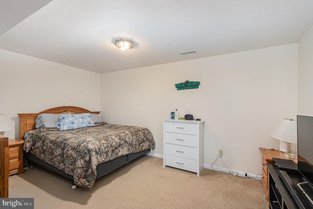bedroom featuring visible vents, baseboards, and light carpet