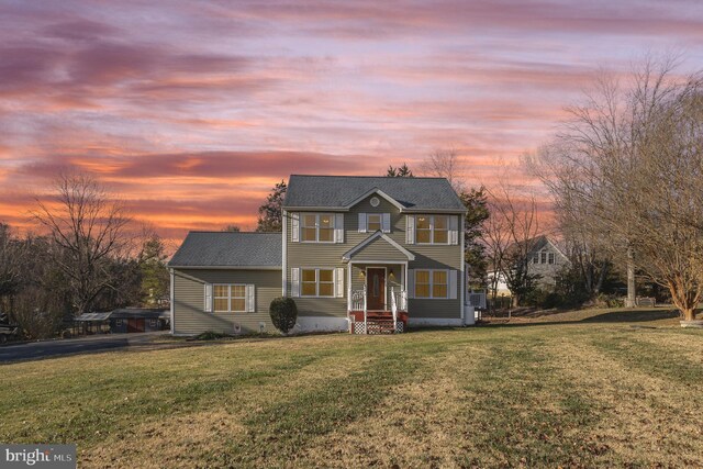 colonial-style house featuring a front lawn
