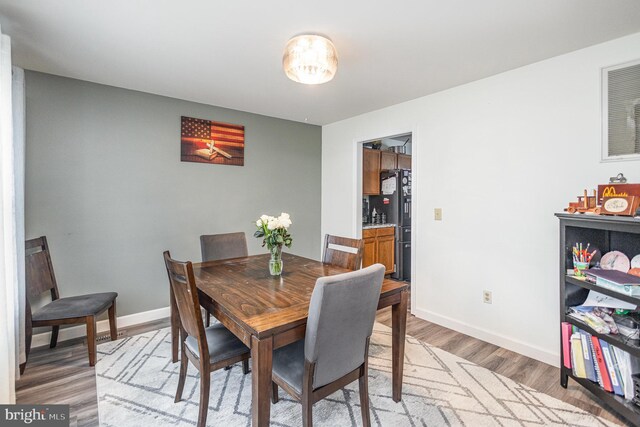 dining area featuring light wood-type flooring and baseboards