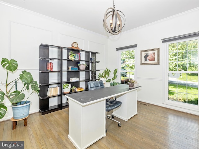 office space featuring ornamental molding, light wood-type flooring, and a chandelier