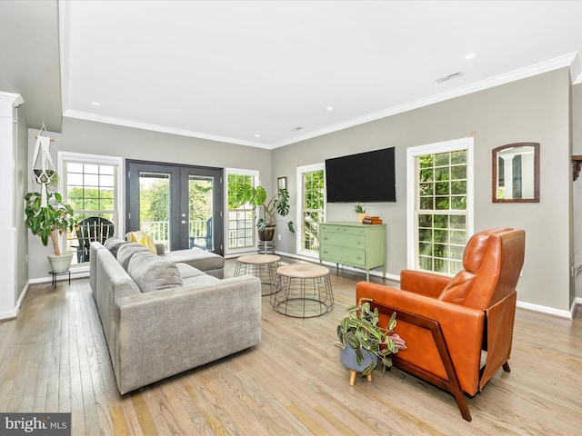 living area featuring french doors, hardwood / wood-style flooring, healthy amount of natural light, baseboards, and crown molding