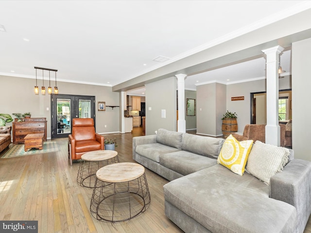 living area featuring decorative columns, wood-type flooring, healthy amount of natural light, recessed lighting, and ornamental molding