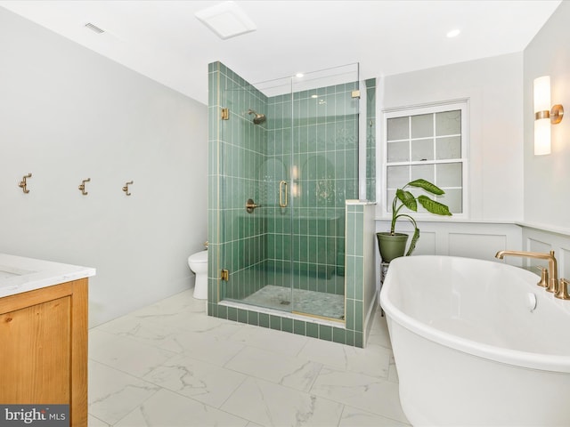 full bath with a shower stall, marble finish flooring, toilet, and a freestanding tub