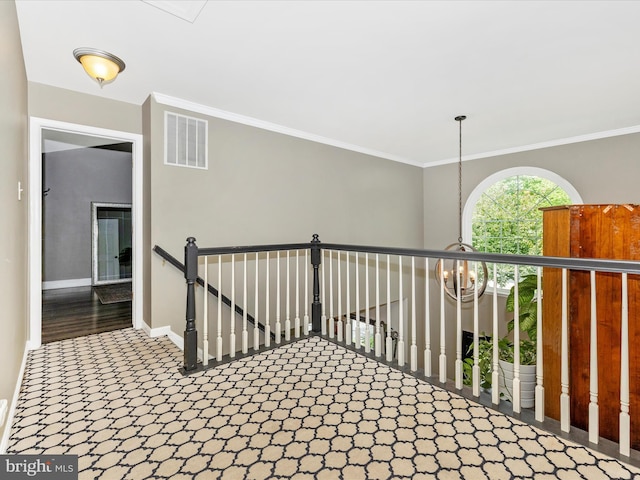 hall featuring baseboards, ornamental molding, an upstairs landing, carpet, and a chandelier