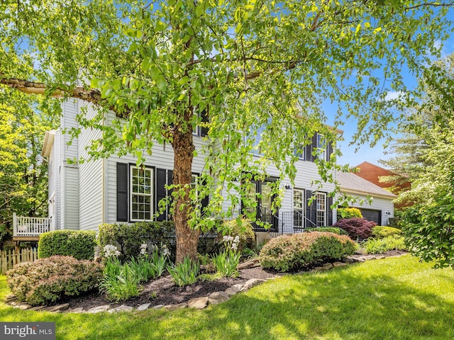 obstructed view of property with a front lawn and an attached garage