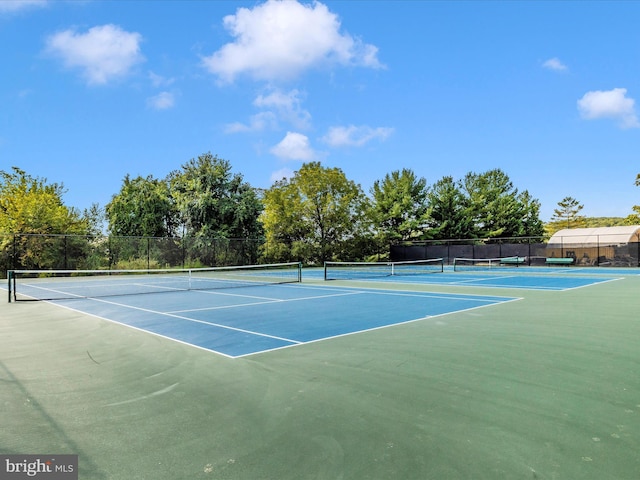view of tennis court with fence and community basketball court