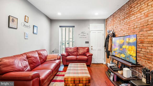 living room with brick wall, wood finished floors, and recessed lighting