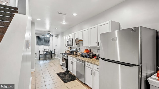 kitchen featuring light tile patterned floors, appliances with stainless steel finishes, baseboards, white cabinetry, and visible vents