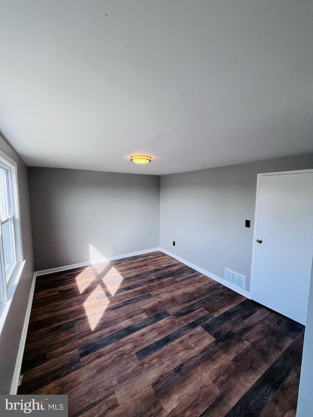 7932 Wynbrook Rd, Baltimore, MD 21224 - unfurnished room featuring visible vents, baseboards, and dark wood-type flooring