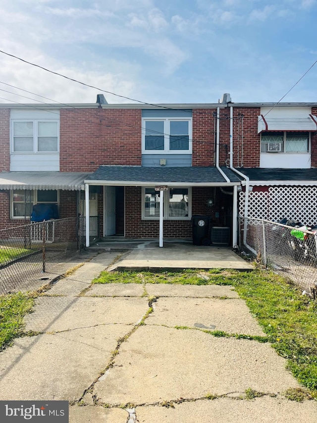 7932 Wynbrook Rd, Baltimore, MD 21224 - townhome / multi-family property with fence, covered porch, cooling unit, and brick siding