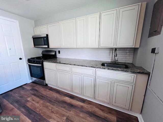 7932 Wynbrook Rd, Baltimore, MD 21224 - kitchen featuring dark wood-style flooring, a sink, range with gas stovetop, stainless steel microwave, and backsplash