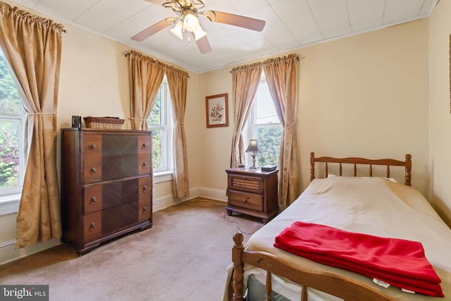 carpeted bedroom featuring baseboards and a ceiling fan