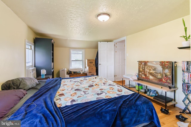 bedroom featuring a textured ceiling and wood finished floors