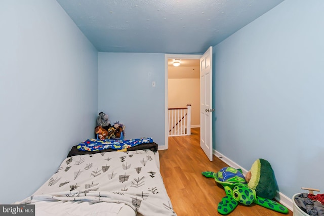 bedroom with baseboards and wood finished floors
