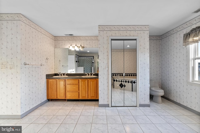 full bathroom with a sink, wallpapered walls, and double vanity