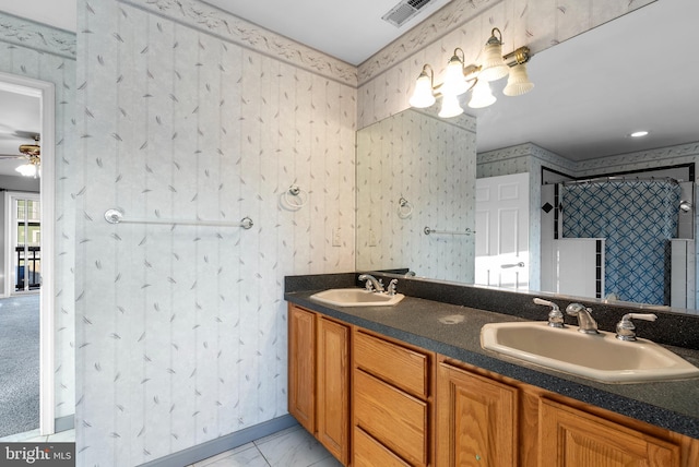 full bathroom with double vanity, wallpapered walls, visible vents, and a sink