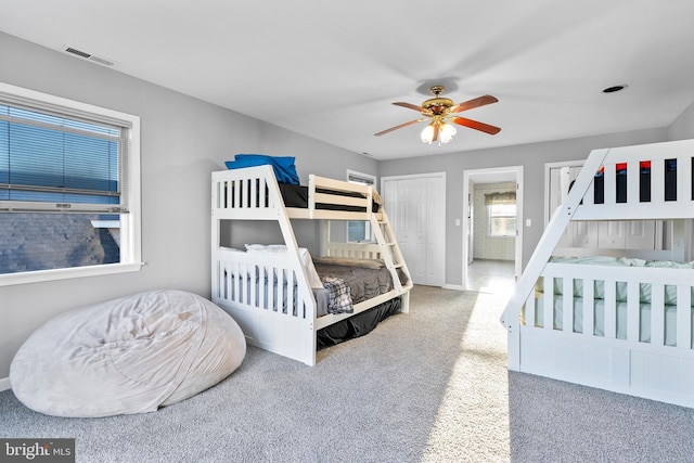 carpeted bedroom featuring baseboards, ceiling fan, and visible vents
