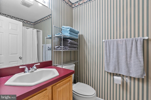 full bathroom with vanity, curtained shower, toilet, and wallpapered walls