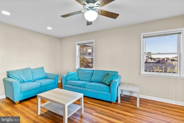 living area featuring a ceiling fan, baseboards, recessed lighting, and wood finished floors