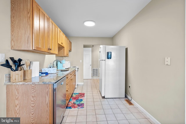 kitchen featuring visible vents, light tile patterned floors, baseboards, light countertops, and white appliances