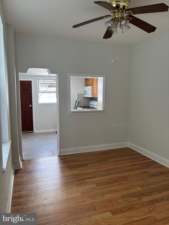 3086 Cedar St, Philadelphia, PA 19134 - empty room with light wood-style floors, a ceiling fan, and baseboards