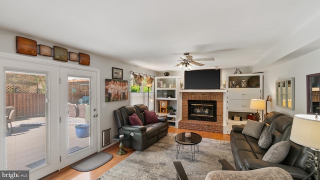 2317 Nantucket Dr, Crofton, MD 21114 - living room featuring a fireplace, a ceiling fan, and light wood-type flooring