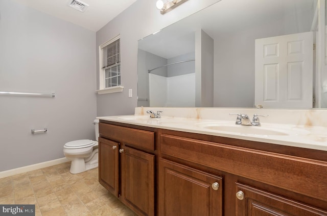 bathroom featuring visible vents, toilet, baseboards, and a sink