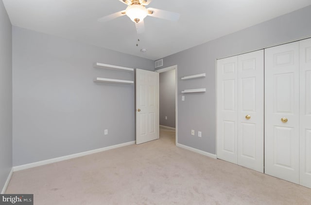unfurnished bedroom with baseboards, visible vents, carpet, a closet, and ceiling fan
