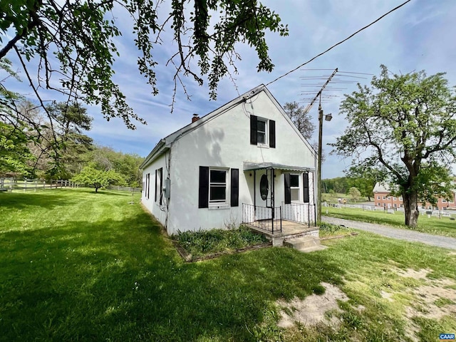 bungalow-style home with fence, a front lawn, and stucco siding