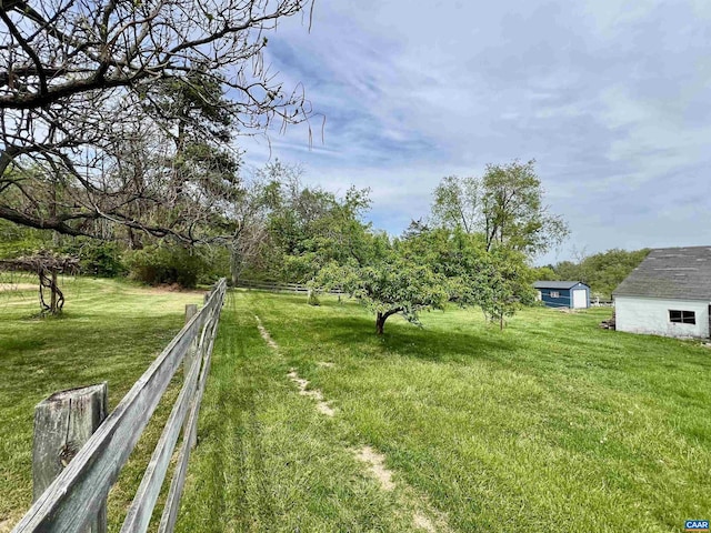 view of yard with fence and an outbuilding