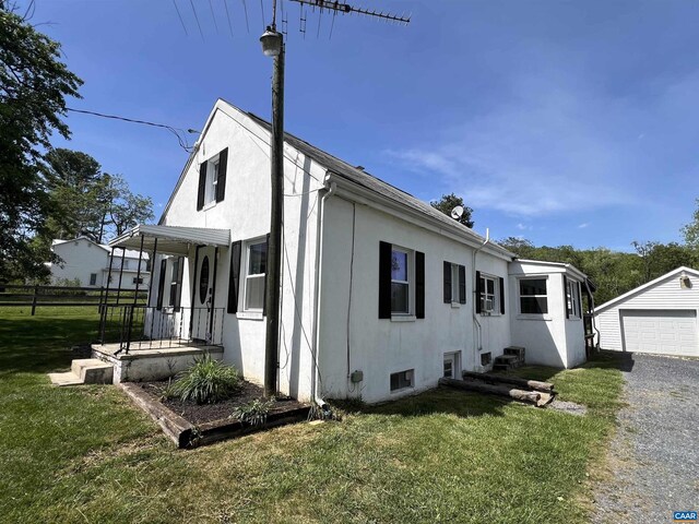 view of home's exterior with a lawn, an outbuilding, and stucco siding