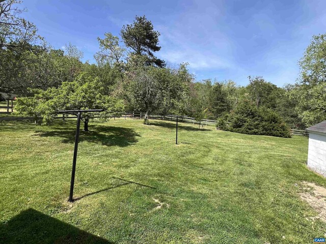view of community with fence and a yard