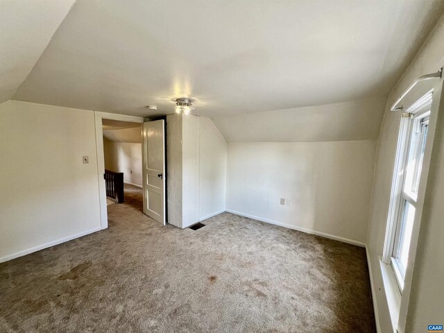 additional living space with carpet floors, baseboards, and lofted ceiling