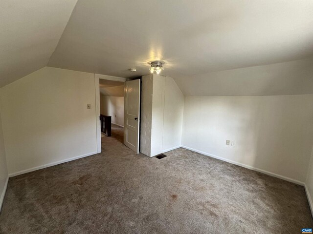 bonus room featuring visible vents, carpet flooring, and vaulted ceiling